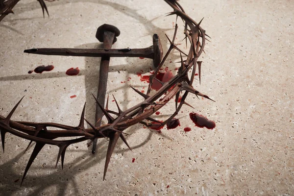 Concept de Pâques. Couronne d'épines avec des clous et des gouttes de sang sur un fond de pierre. — Photo