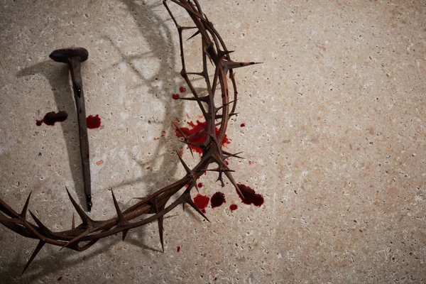 Concepto de Pascua. Corona de espinas con uñas y gotas de sangre sobre un fondo de piedra. —  Fotos de Stock