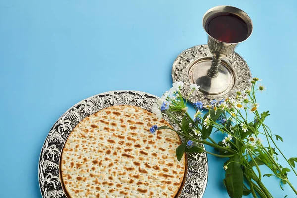 ペサお祝いの概念は、ユダヤ人過越の休日。マツァと赤コーシャ。青い背景に伝統的なユダヤ教のパン — ストック写真