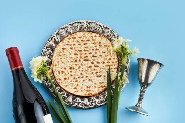 Pesah kutlaması konsepti, Yahudi bayramı. Matzah ve kırmızı koşer. Geleneksel Yahudi ekmeği mavi arka planda