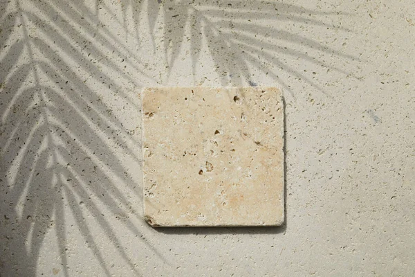 Travertine Taşı, travertin taşından arka planda ve palmiye gölgesinde düz bir podyum sergiliyordu. Ürün tanıtımı Güzellik kozmetik vitrini.