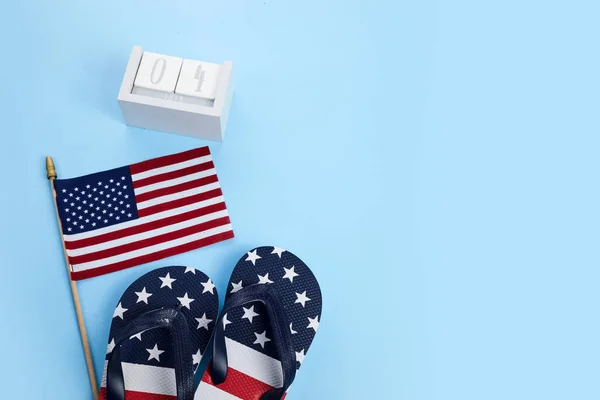 Patriotic USA background with flip flops and American flag.