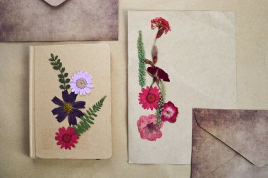 Beautiful dried flowers and notebook on vintage background.