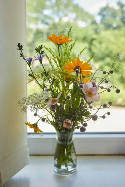 Beautiful bouquet of wildflowers isolated on windowsill