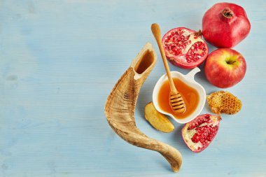 Rosh hashanah, jewish New Year holiday concept. Pomegranate, apples and honey traditional products for celebration.