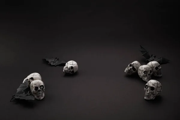ハロウィン 黒の背景に表彰台黒コウモリと頭蓋骨 — ストック写真