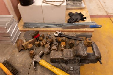 Demirci atölyesinde çalışıyor. Metaller ve çalışma masasıyla.