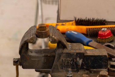 Demirci atölyesinde çalışıyor. Metaller ve çalışma masasıyla.