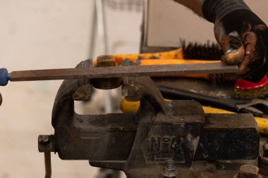 Demirci atölyesinde çalışıyor. Metaller ve çalışma masasıyla.