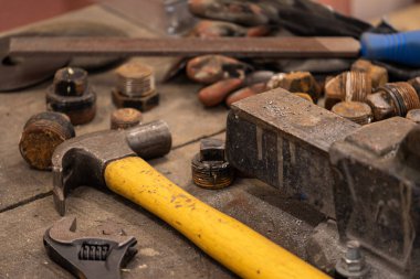 Demirci atölyesinde çalışıyor. Metaller ve çalışma masasıyla.