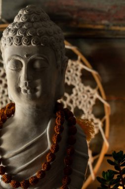 Buda heykeli mihrapta mumlar ve bitkilerle