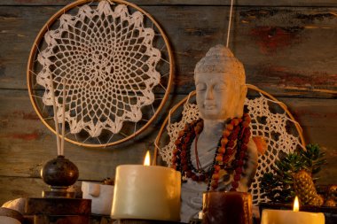 buddha statue image on altar with candles and plants