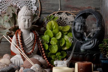 Buda heykeli mihrapta mumlar ve bitkilerle