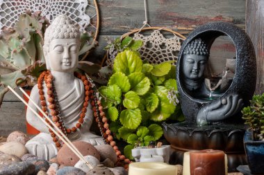 Buda heykeli mihrapta mumlar ve bitkilerle