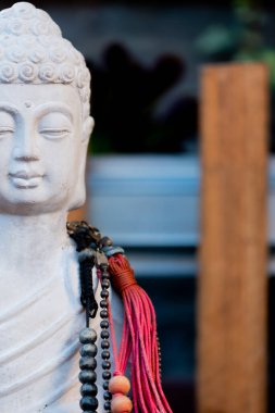 Buda heykeli mihrapta mumlar ve bitkilerle