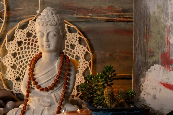 Buda heykeli mihrapta mumlar ve bitkilerle