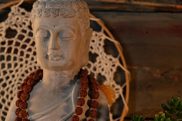 Buda heykeli mihrapta mumlar ve bitkilerle