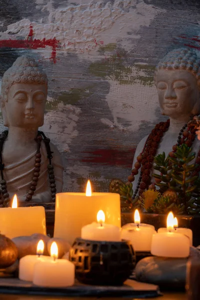 Buda heykeli mihrapta mumlar ve bitkilerle