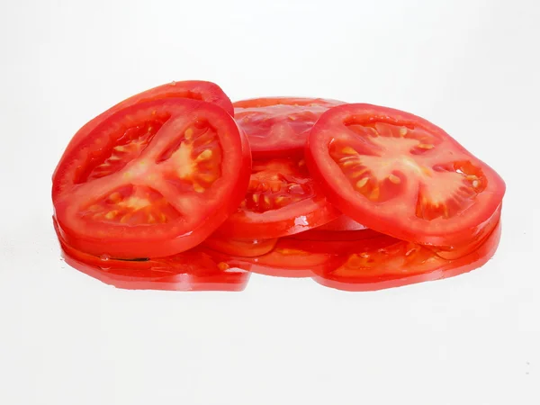 Sliced tomato on the mirror — Stock Photo, Image