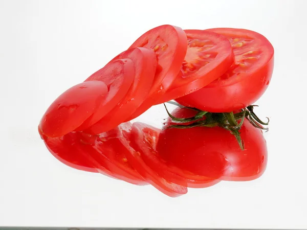 Sliced half tomato on the mirror — Stock Photo, Image