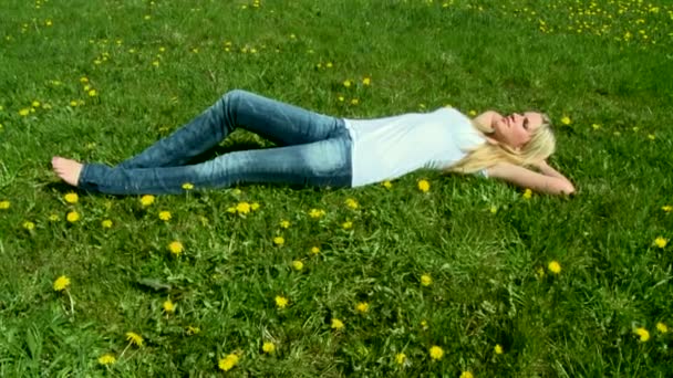 Mujer acostada sobre hierba verde — Vídeo de stock