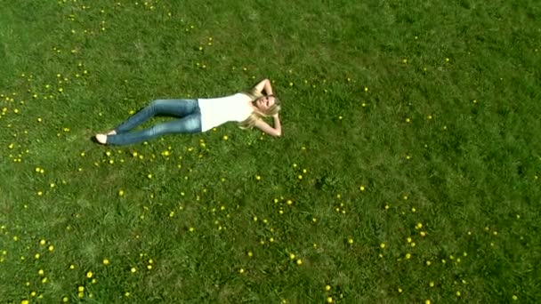 Vrouw opleggen van groen gras — Stockvideo