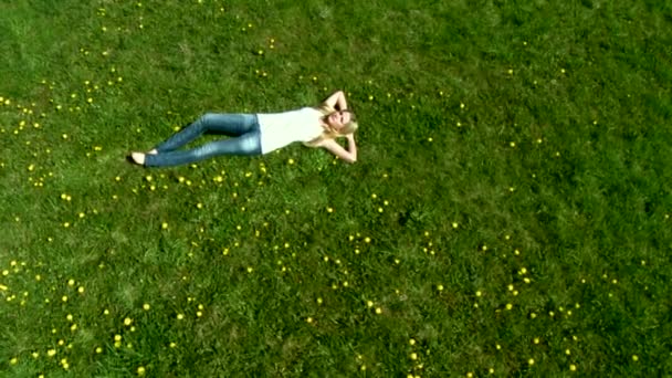 Mulher que coloca na grama verde — Vídeo de Stock