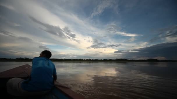 Человек в лодке, у реки Амазонки — стоковое видео