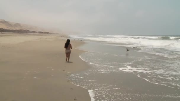 Frau läuft am Strand — Stockvideo