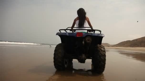 Mujer conduciendo quad en la playa — Vídeo de stock