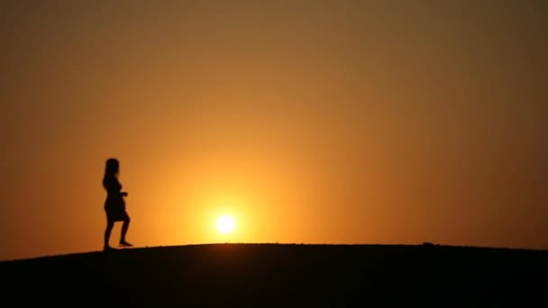 Mulher na frente do pôr do sol silhueta — Vídeo de Stock