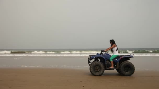 Mulher dirigindo quadriciclo na praia — Vídeo de Stock