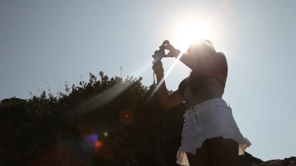 Mujer tomando fotos en la playa — Vídeo de stock