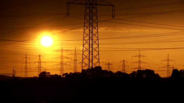 Stožáry elektrické energie při západu slunce — Stock video