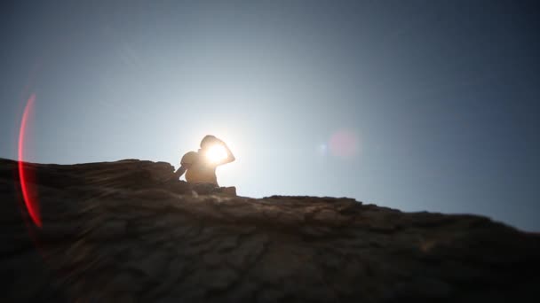 Hombre en la roca en el sol — Vídeo de stock