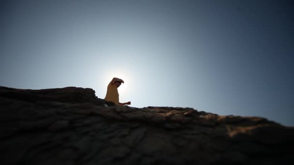 在阳光下的岩石上的男人 — 图库视频影像