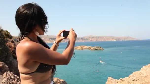 Mujer tomando fotos en la playa — Vídeo de stock