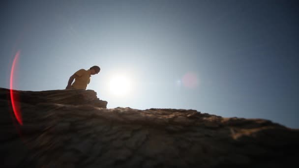 Mann auf Felsen in der Sonne — Stockvideo