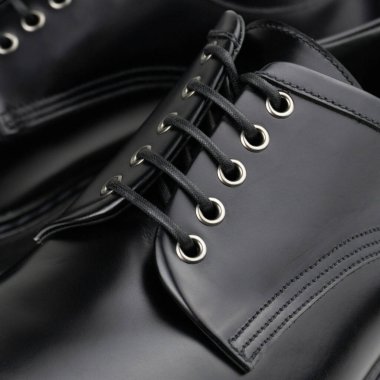 Siyah deri derbi, metal gözlerle birbirine bağlanmış.