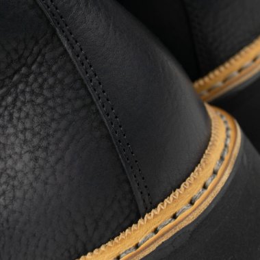 Siyah yürüyüşçü botları. Topuklu ayakkabılar. Yakın plan.