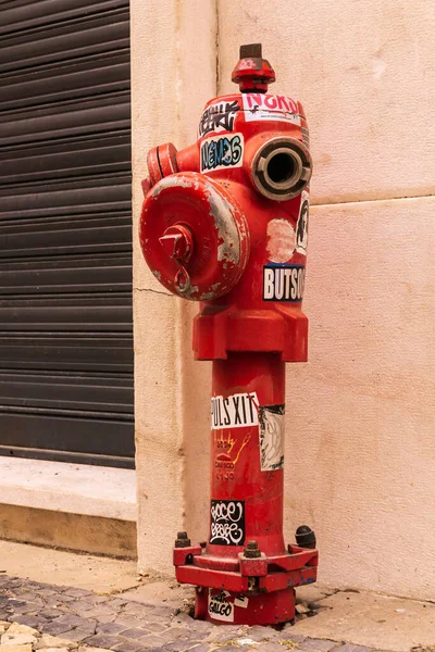 Lizbon 'da çıkartmalarla kaplı eski bir yangın musluğu.