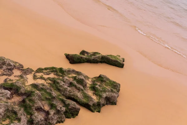 Waves roll on red sand and gray rocks — Stock Photo, Image