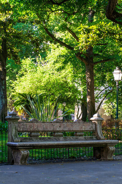 Old granite bench in the park on a sunny summer day