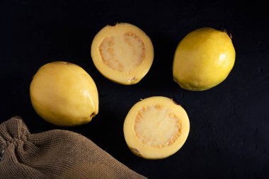 Siyah arka planda sarı guava, durgun bir yaşam tarzı. Sağlıklı beslenme