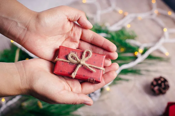 Tahta arka planda, sıcak ve soğuk tonlarda mini Noel hediyeleri.