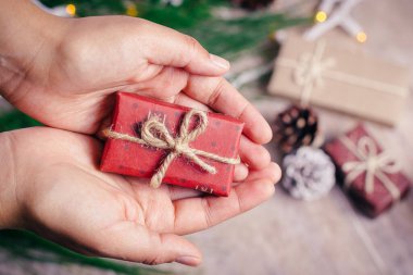 Tahta arka planda, sıcak ve soğuk tonlarda mini Noel hediyeleri.