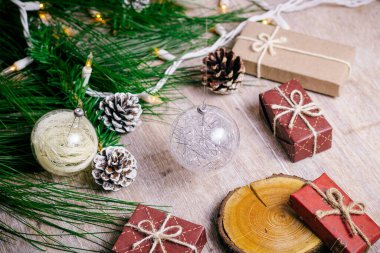 Tahta arka planda, sıcak ve soğuk tonlarda mini Noel hediyeleri.