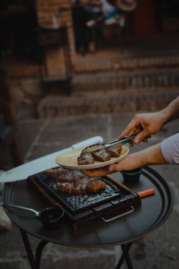 Izgara mutfağı. Şef füme domuz pirzolası kesmek için bıçak kullanır..