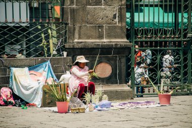 Sanatçılar, Puebla Katedrali 'nin dışındaki Palm Sunday kutlamalarında palmiye figürleri satıyor. 