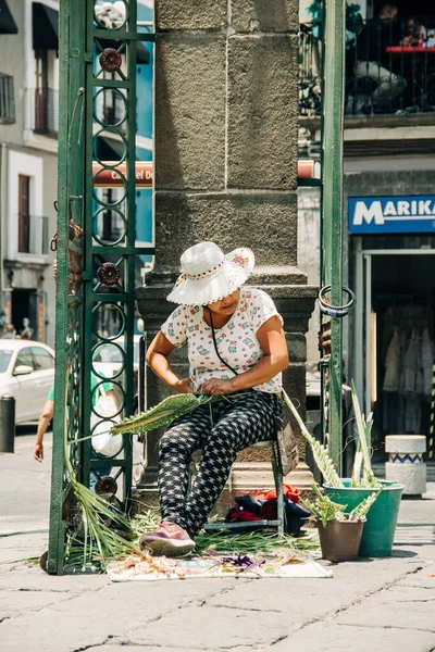 Sanatçılar, Puebla Katedrali 'nin dışındaki Palm Sunday kutlamalarında palmiye figürleri satıyor. 